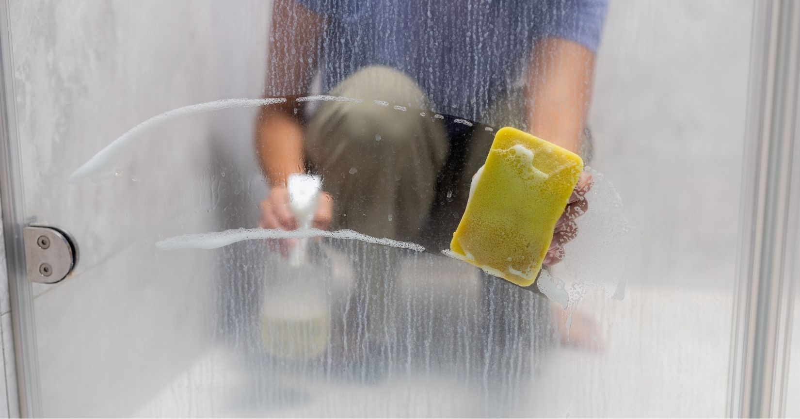 someone cleaning limescale off a shower